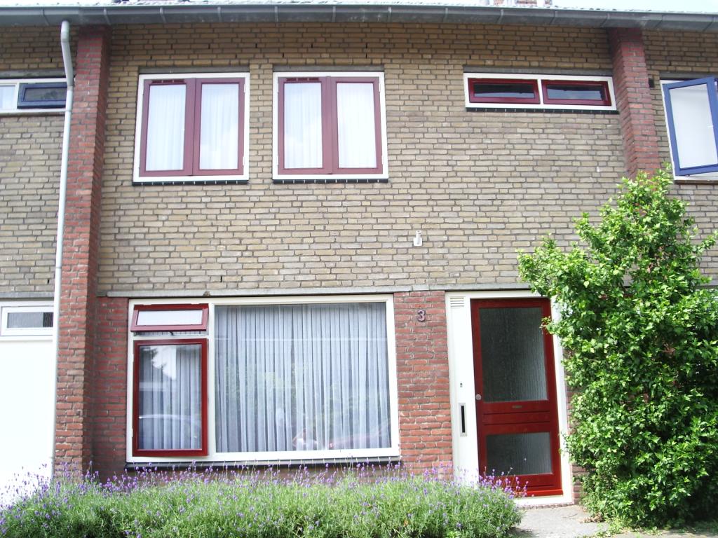 Dezelfde gevel na het schilderwerk: kozijnen, ramen en voordeur in diep rood geschilderd