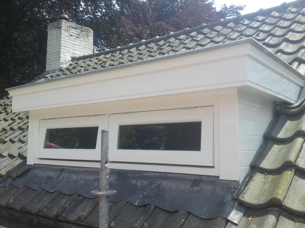 Pas geschilderde witte dakkapel op een pannendak