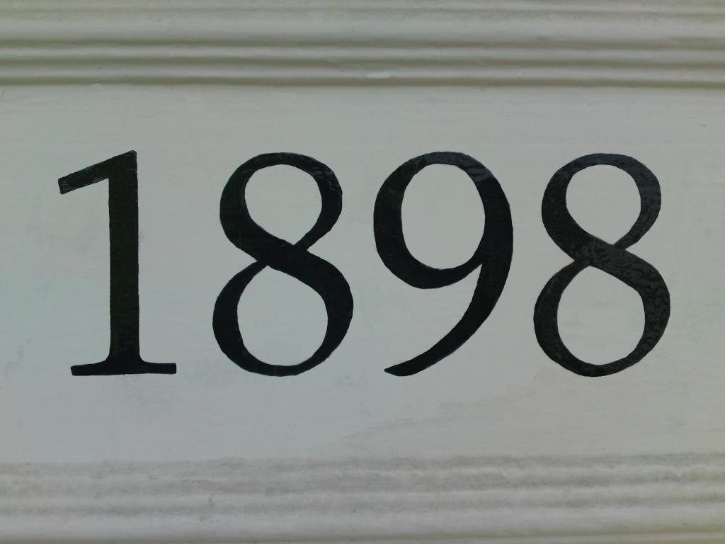 Met de hand gepenseeld jaartal 1898 in zwarte cijfers op een witte lijst